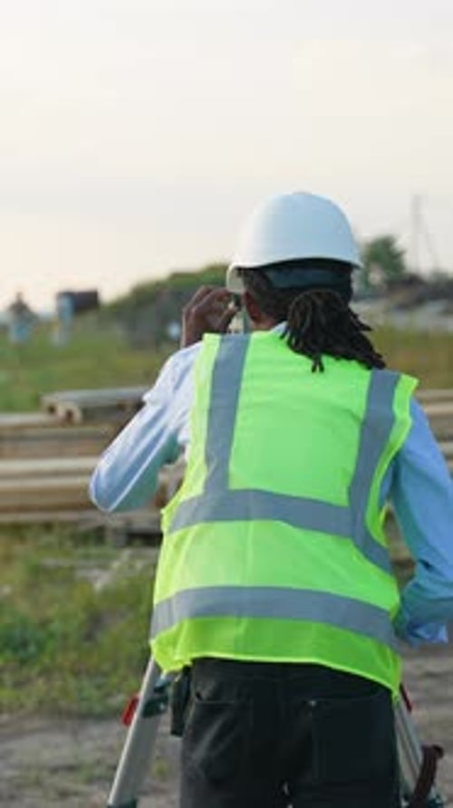 Construction Engineer Using Equipment at Work Site