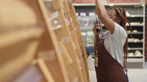 Trabalhador de supermercado verificando a quantidade de pão