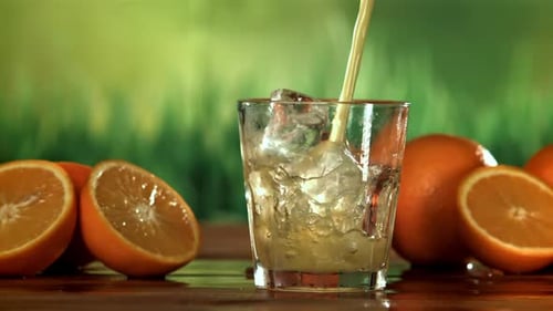 Pouring Refreshing Orange Juice Into Glass With Ice