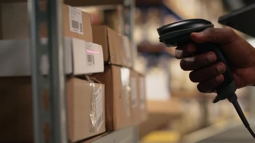 Close Up of Black Worker Using a Barcode Scanner to Process Shipping Labels