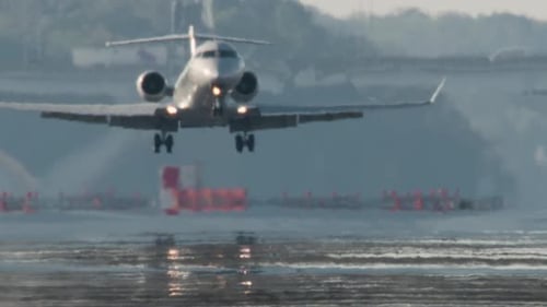 Small Jet Lands with Puff of Smoke from Tires with Mirage on Runway