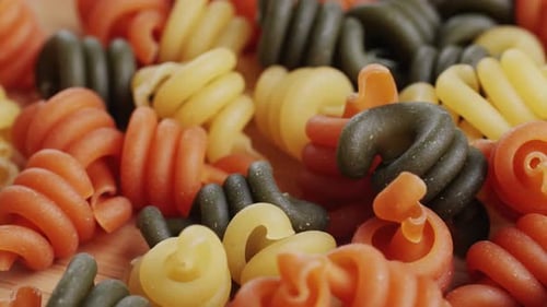 Colorful uncooked spiral pasta close up food concept