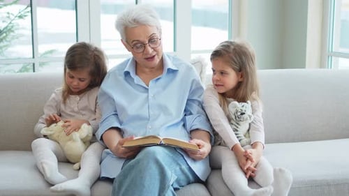 Grandmother Reading Story to Grandchildren on Couch