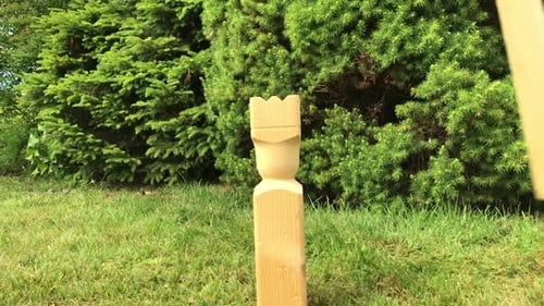 Juego sueco kubb. El rey recibe un golpe en cámara lenta. En el jardín trasero.