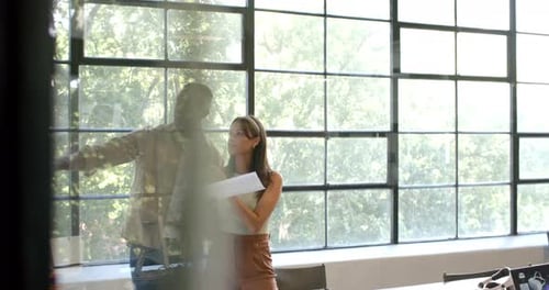 Discussing project, colleagues holding documents and tablet in modern office setting, copy space