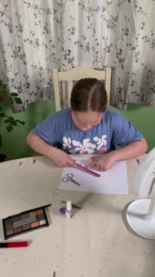 Teen Girl Filing Nails at Table Indoors