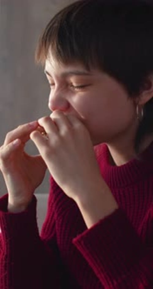 Closeup Vertical Footage of a Teenager Girl Eating Burger While Sitting at a Cafe