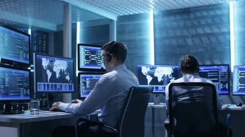 Panorama Shot of System Control Room with Three Technical Controllers Working at Their Workstations