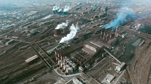 Aerial view of large industrial area consisting of power plants and factories with smoke coming out