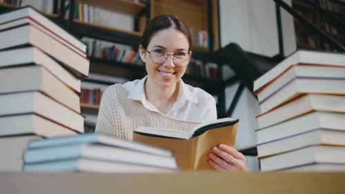 Portrait of Young Woman Student or Businesswoman Reading in the Library Students in a Good Mood