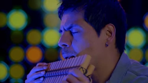 Nahaufnahme eines Musikers, der ein Panflöteninstrument aus den Anden Perus und Boliviens spielt