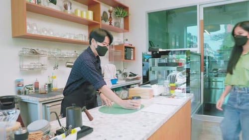 Asian woman Wear Protective Face Mask giving take home coffee cup to customer