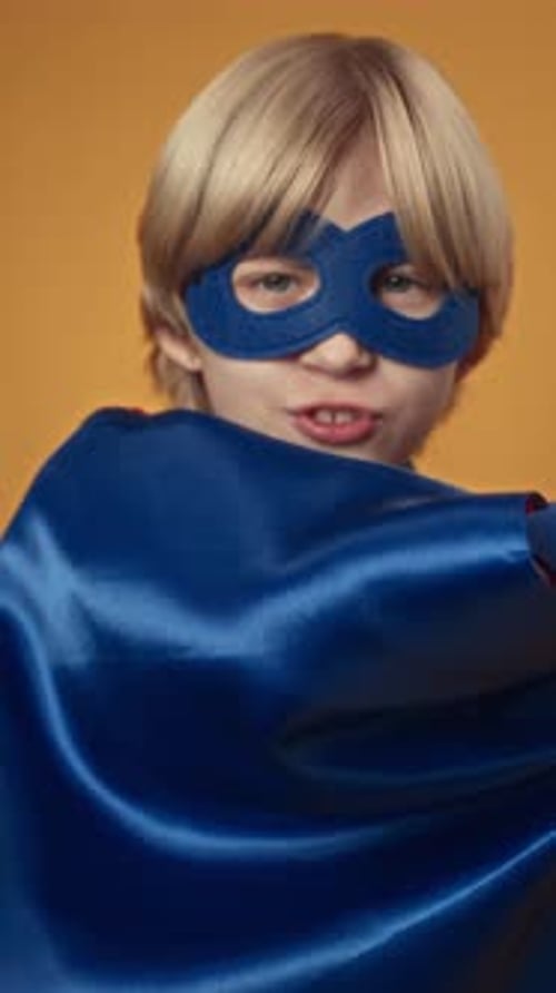 Boy in Superhero Costume Swinging His Cape at Camera