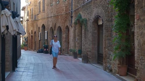 Tourist Walking Down a Picturesque Street in San Gimignano