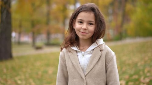 Smiling Girl Blowing Kiss in Autumn Park