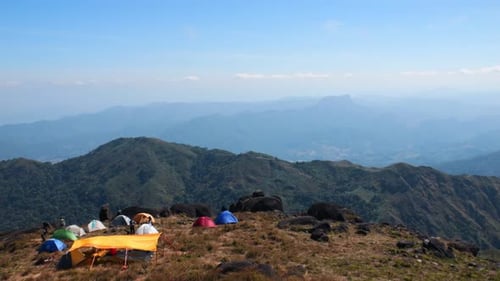 Camping in den Bergen mit Zelten auf einem hohen Hügel.