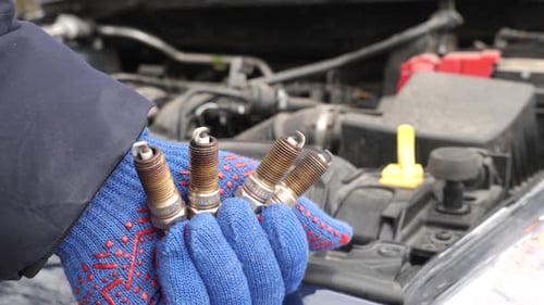 03. The master replaces the old spark plugs in the car. Car service.