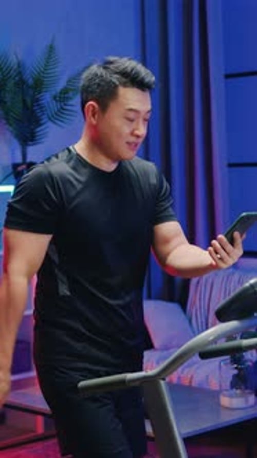 Man on treadmill video calling at home