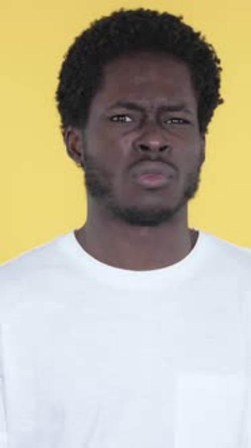 Young Man Gesturing No on Yellow Background Portrait