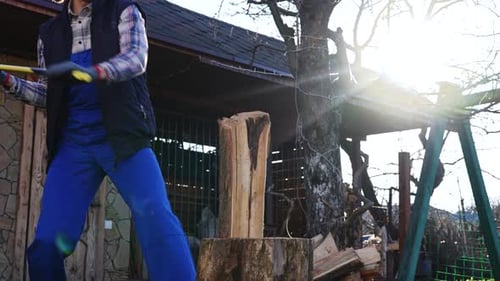 A Young Man Chops Wood for a Warm Winter in His Rural Homestead