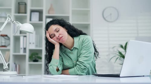 Exhausted sleeping young worker woman employee sitting at computer desk in office at workplace tired