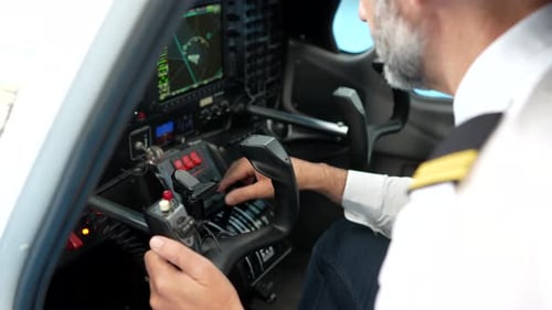 Professional Pilot Operating Aircraft Controls in Cockpit