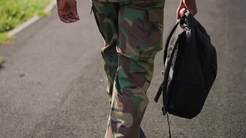 Young Man Walks with Backpack in Camo Gear