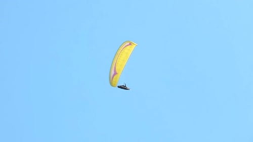 Fliegender Gleitschirm am blauen Himmel, Freiheits- und Abenteuerkonzept, Adrenalinsport