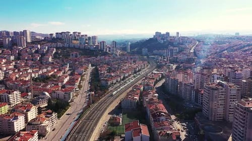 Drohnenvideo von Bahngleisen, die durch die Stadt fahren, und eines Zuges, der am Bahnhof hält