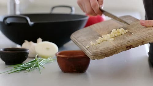 Girl Adding Freshly Chopped Garlic Into Ceramic Bowl