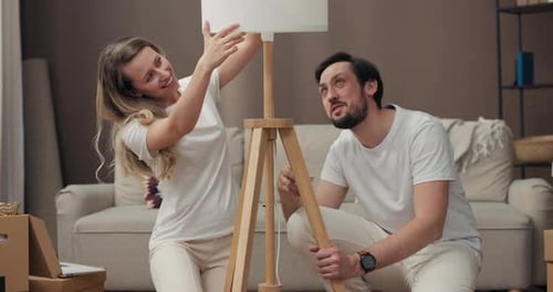 Couple Assembling Floor Lamp Together in Living Room