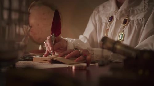 Person Writing with Feather Quill and Antique Globe