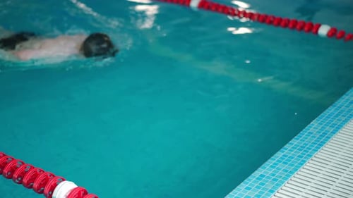 Man Swimming Freestyle in Indoor Pool
