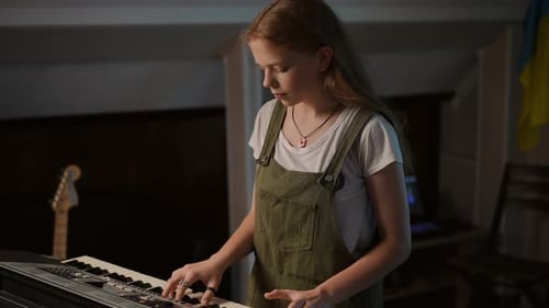 A Girl with Long Hair Makes a Mistake When Playing a Synthesizer While Standing in a Music School