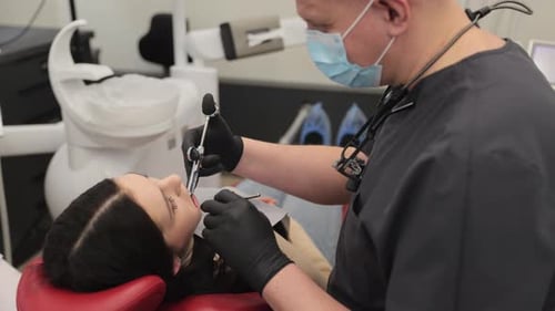 Skilled Dentist Performs a Dental Procedure on a Patient in a Contemporary Clinic