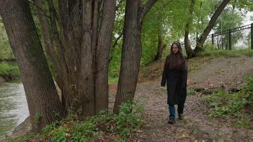 Serene Woman Near Flowing Water Solitary Female Standing Beside Calm River Solitary Woman Dressed in