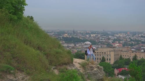 Couple Enjoys City View from Rocky Hilltop
