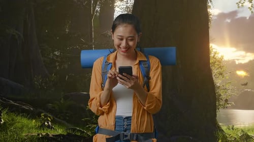 Asian Female Hiker Enjoy Using Smartphone While Exploring Forest Nature