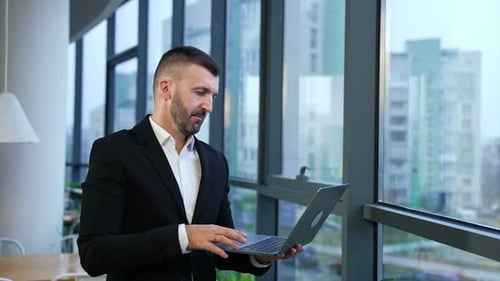 Handsome man notebook work. Businessman successful working with laptop in modern office.