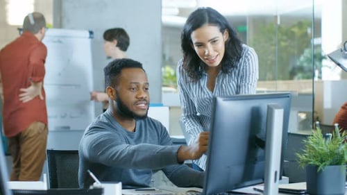 In the Busy Corporate Office Male and Female Together Solve Work Related Problems, Using Personal C