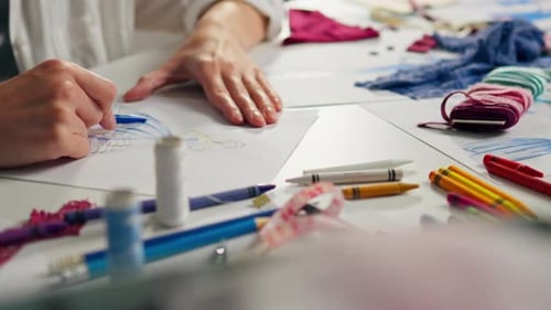 Designer Drawing Fashion Sketch with Blue Pencil