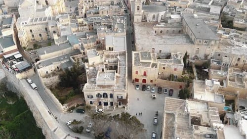Mdina city walls and old cityscape, near the Cathedral of Saint Paul - Aerial Fly-over slow tilt up