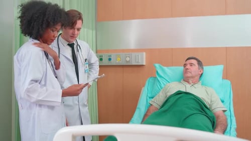 Doctors Talking with Patient Lying in Hospital Bed