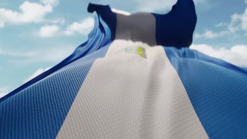 Realistic Waving Nicaragua Flag Against Blue Sky