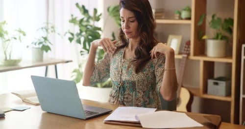 Woman Stretching and Looking at Laptop at Home