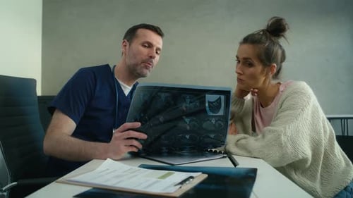 Doctor Showing Patient Brain Scan Results in Office