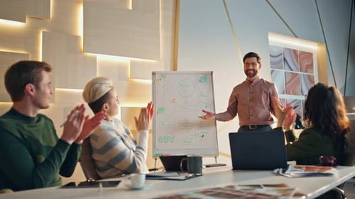 Business team clapping hands to smart man speaker in office conference room