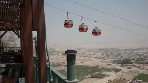 Red Gondolas Overlooking Expansive City Landscape During Daytime