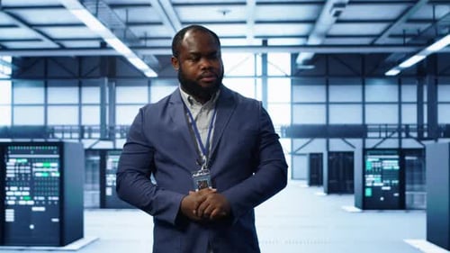 Technician Walking Between Server Rows in Data Center Doing Inspection