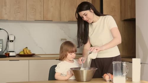 Woman and Child Cooking Together in Kitchen
